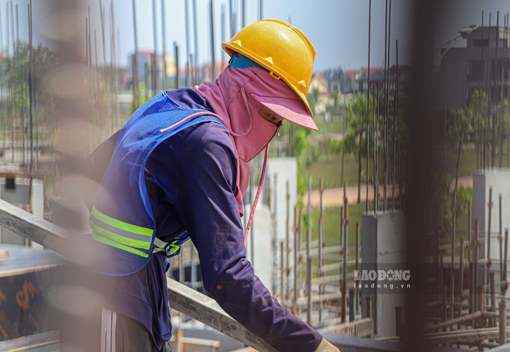 Công nhân trùm kín người để tránh tiếp xúc với ánh nắng gắt. Ảnh: Nguyễn Luân