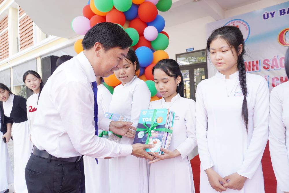 Mr. Le Phu Nguyen - Chairman of Hoa Vang Commune People's Committee - presents free textbooks to students. Photo: Tran Thi