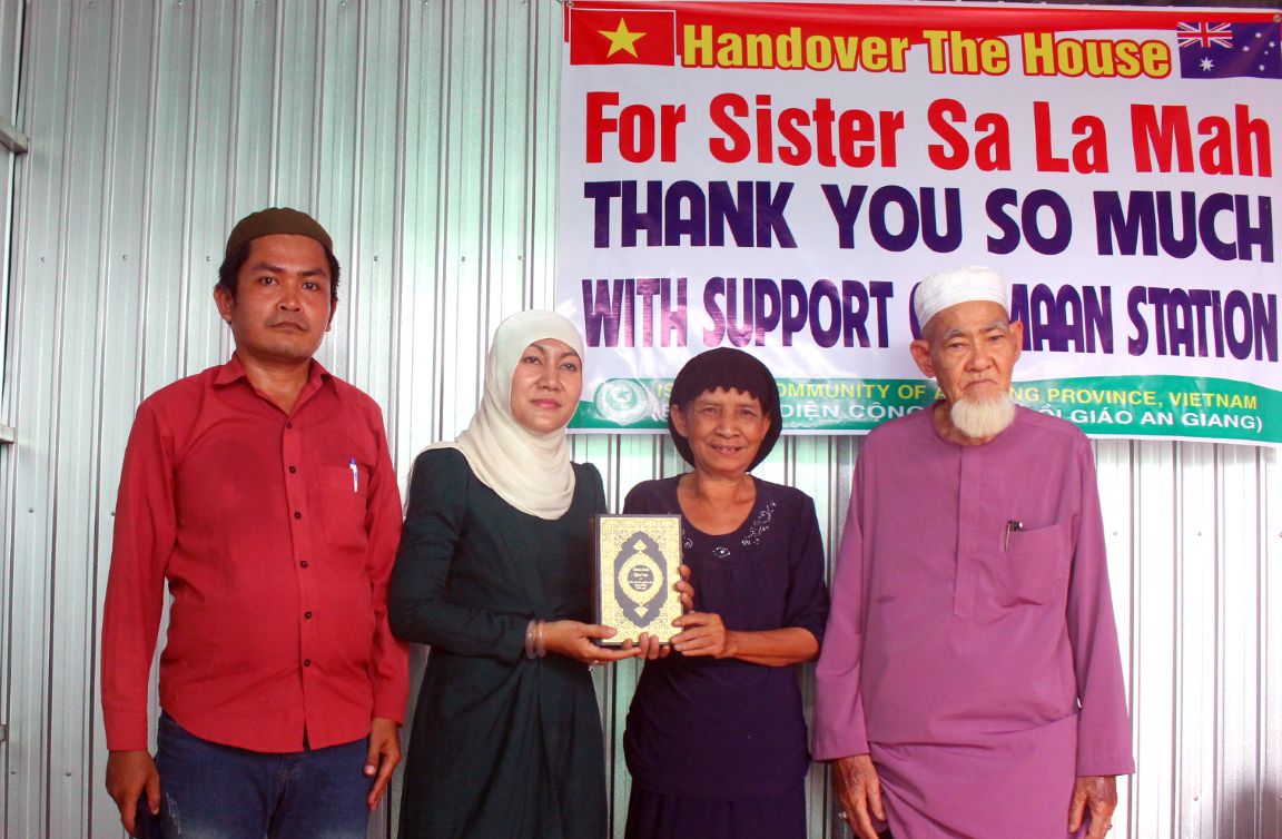 Trao tặng Thánh kinh Cô-ran cho người nhận nhà mới. Ảnh: Thanh Mai