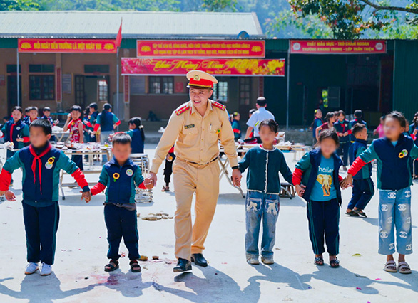 Nghe An Provincial Traffic Police and students of Muong Long 2 Primary School participate in experiential activities in the schoolyard. Photo: Thien Thao