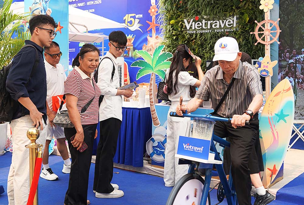 VITM 2026フェアのブースで、エネルギーを生成してスムージーを作るミニゲームを体験する顧客。写真:ハ・アイン