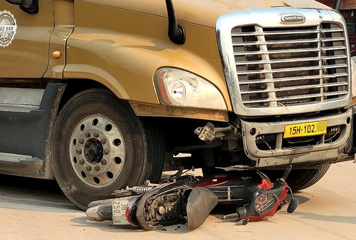 컨테이너 트럭과 오토바이 충돌 사고 현장, 2명 부상. 사진: Đức Tuấn