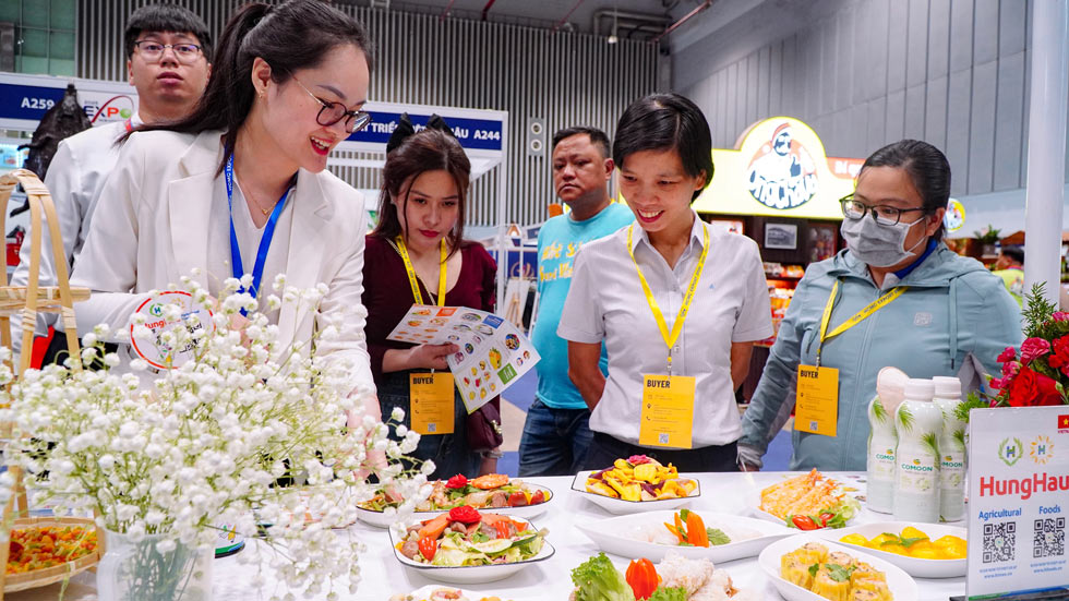 専門展示会でHungHau Foodsの食品製品を見学し、試用する顧客。写真:DN提供