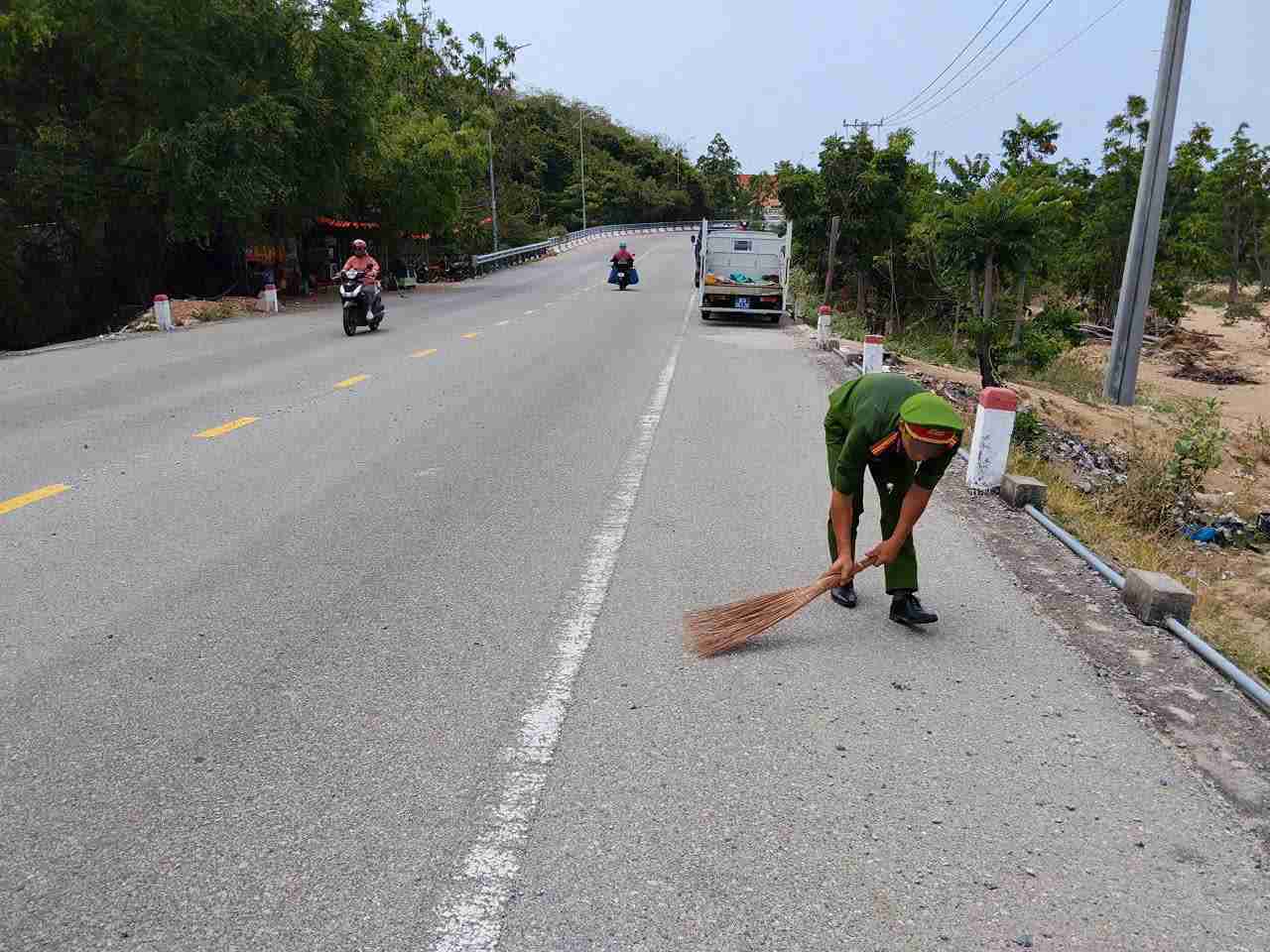 Commune police and people clear scattered gravel on the road. Photo: Vinh Hai Police