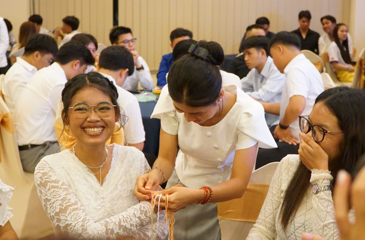 Nghi lễ buộc chỉ cổ tay gửi lời chúc may mắn. Ảnh: Thanh Chân