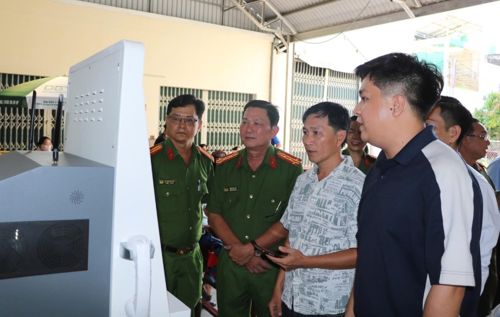 Los delegados experimentan la realidad de los quioscos de IA que sirven a la administración pública en la sede de la Policía. Foto: Tien Dung