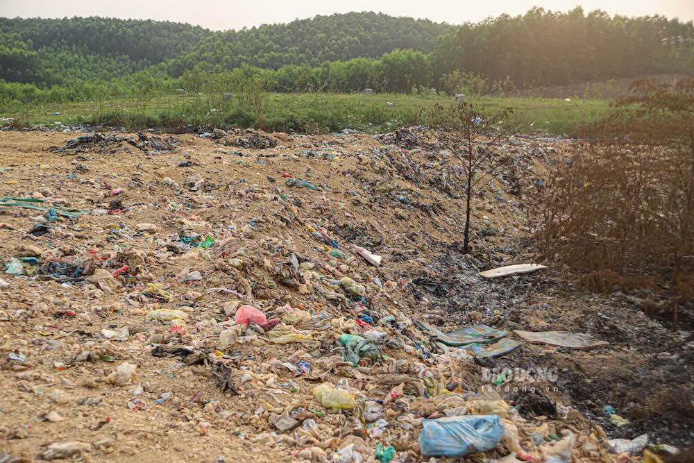 Đất được các xe tải chở đến vùi lấp các điểm cháy tại bãi rác. Ảnh: Nguyễn Luân 