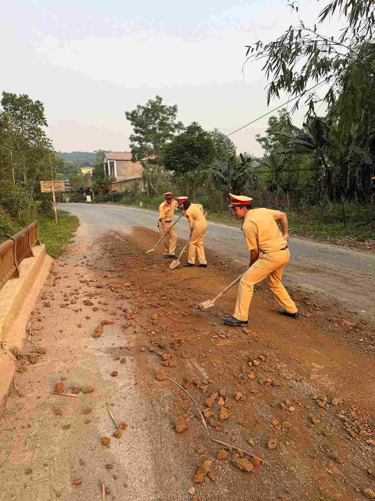 Cán bộ, chiến sĩ Phòng Cảnh sát giao thông đã trực tiếp tham gia thu dọn số đất, đá rơi vãi trên mặt đường. Ảnh: Công an Cao Bằng