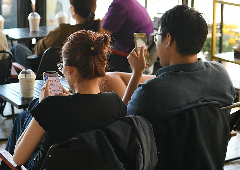 Sitting together but each person is in a different "world". Photo: Viet Van