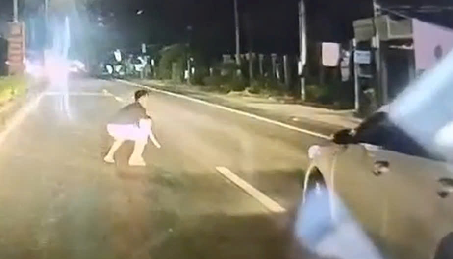 Tài xế kịp thời bế cháu bé vào vị trí an toàn. Ảnh cắt từ clip bạn đọc cung cấp