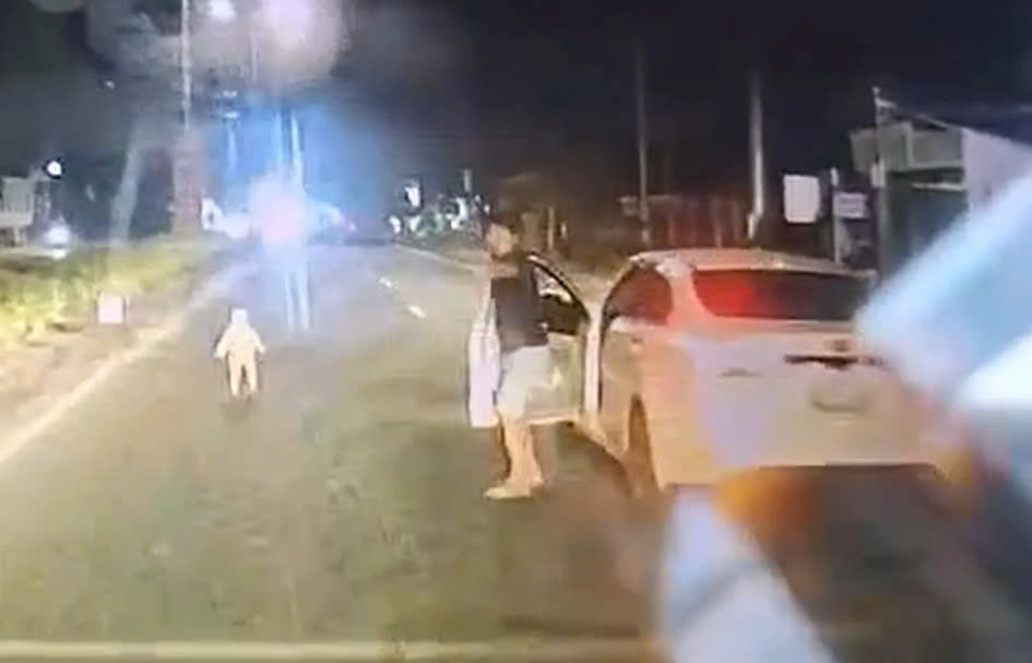 Driver discovers and rescues child running alone in the middle of the road at night. Photo cut from clip provided by reader