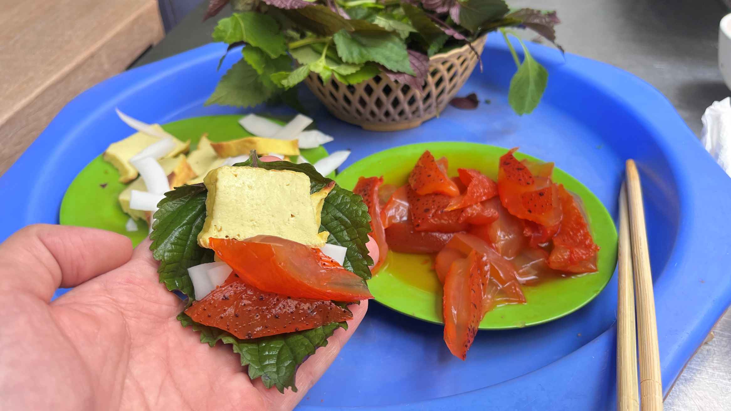 Sứa đỏ tươi giòn sần sật cuốn cùng lá tía tô, đậu nghệ nướng, cùi dừa non và rau thơm, chấm mắm tôm đậm đà. Ảnh: Thùy Dương