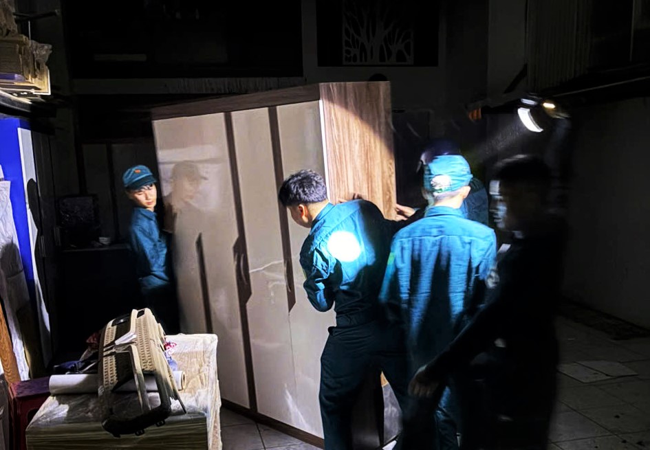 Lực lượng dân quân tập trung di chuyển tài sản, đồ đạc ra khỏi vụ cháy. Ảnh: Võ Đoan