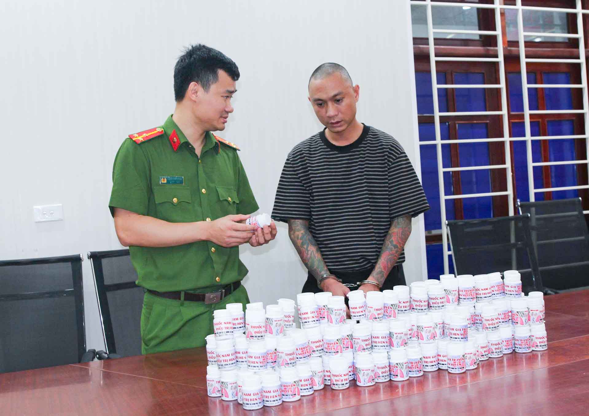 Đối tượng Nguyễn Duy Sơn cùng số tang vật là thuốc giả. Ảnh: Hồ Hưng