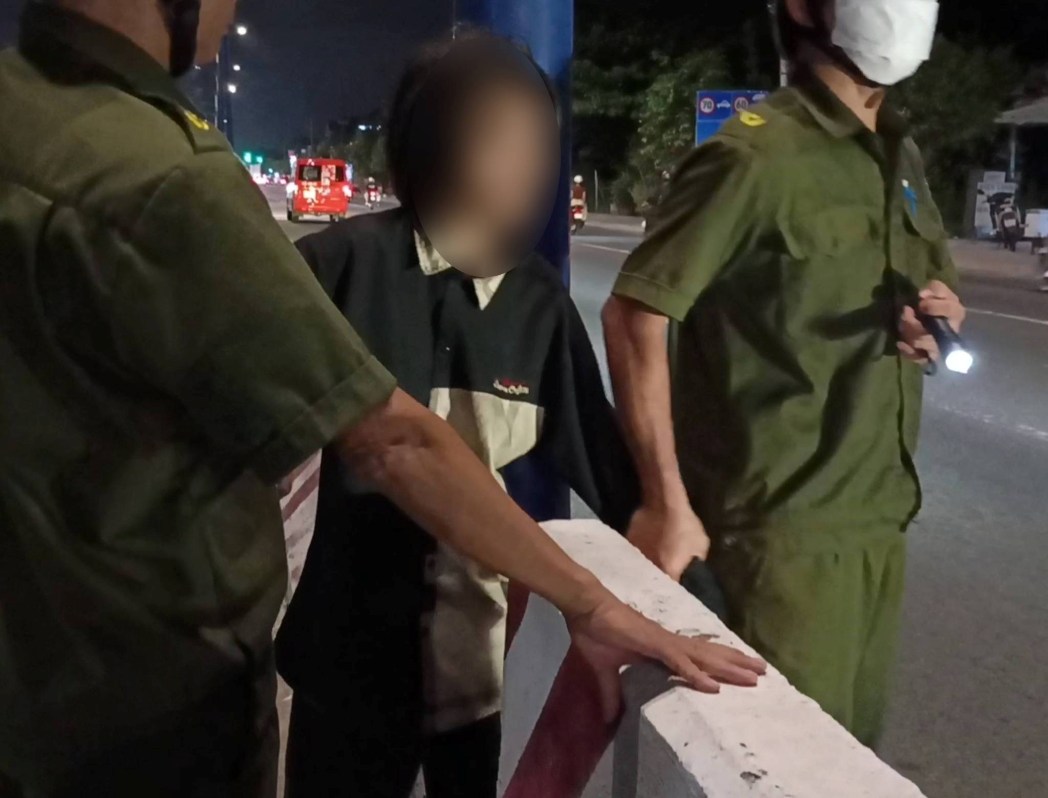 Lực lượng chức năng đã đưa cô gái vào lề đường đảm bảo an toàn. Ảnh: Bạn đọc cung cấp