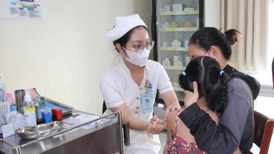 Parents take their children to Vinh Long CDC for vaccination against meningococcal meningitis. Photo: Hoang Loc