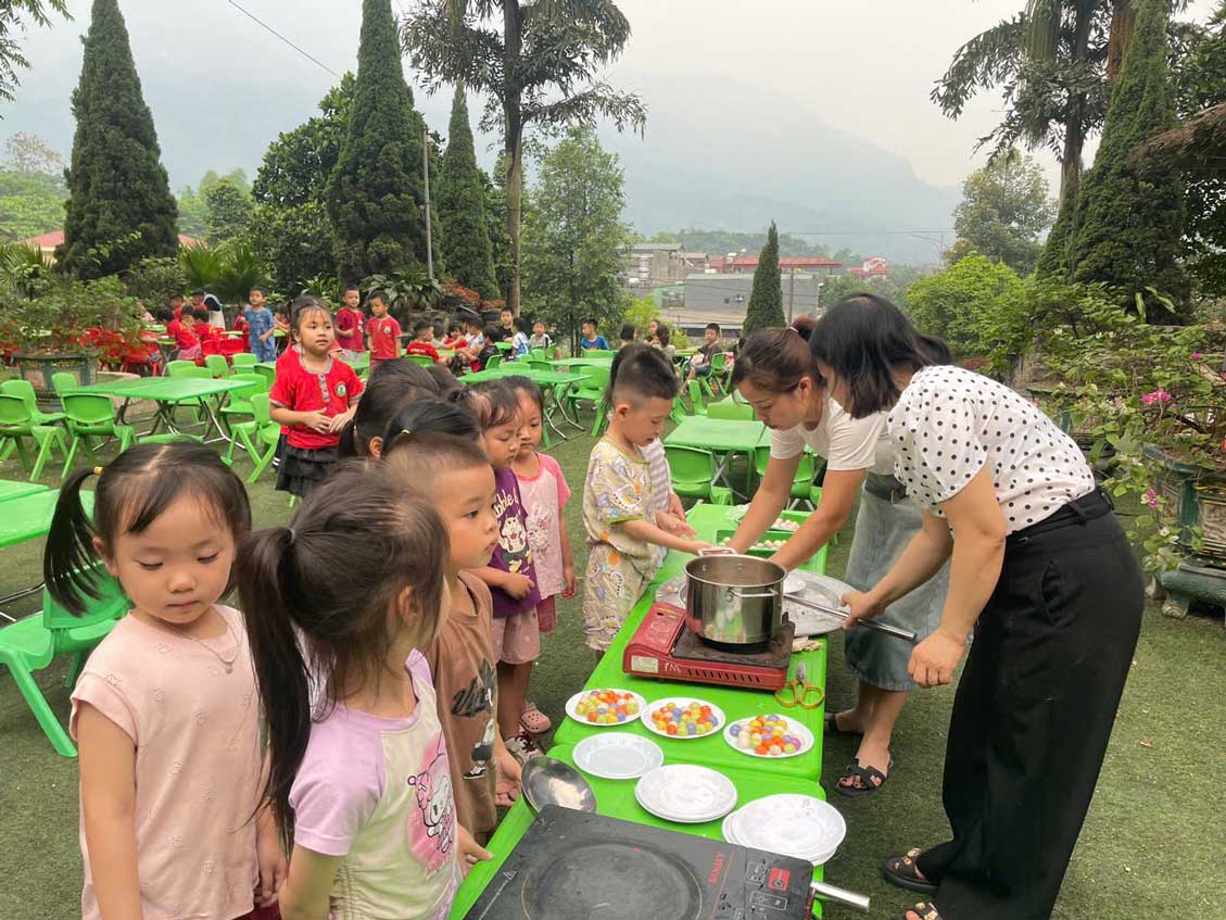 Các em nhỏ thích thú quan sát công đoạn luộc bánh, chờ bánh chín nổi. 