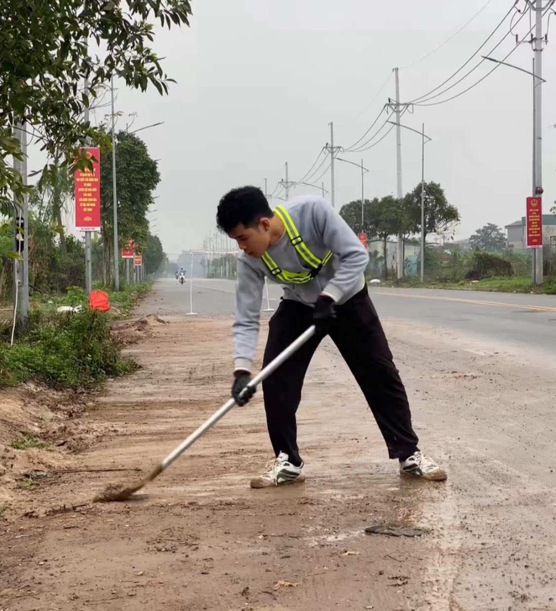 Ngoài vá ổ gà, “chàng trai vá đường” còn dọn bùn đất rơi vãi trên đường, 