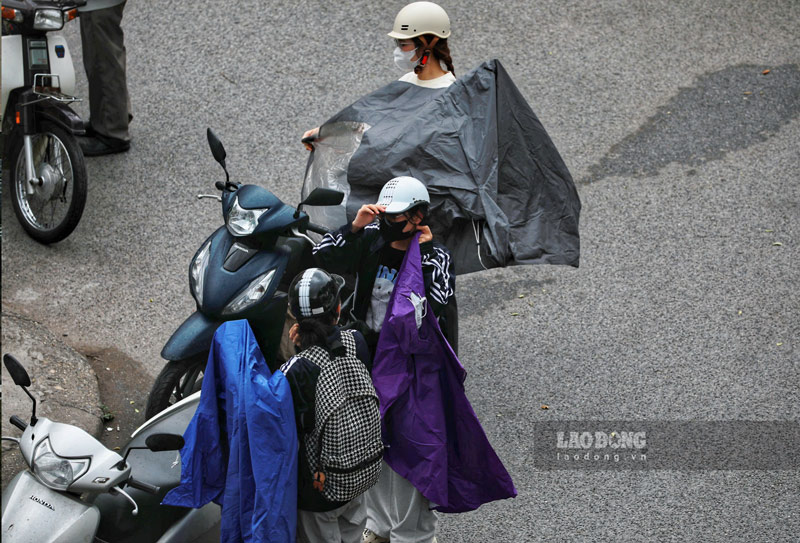 Thỉnh thoảng xuất hiện những cơn mưa nhỏ, khiến người dân phải dừng lại mặc áo mưa. Ảnh: Tô Thế