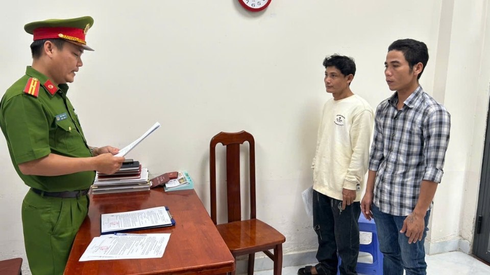 Cơ quan Công an tống đạt các quyết định khởi tố đối với bị can Lâm Văn Hảo (áo trắng) và Trang Răng Xây. Ảnh: Công an Vĩnh Long