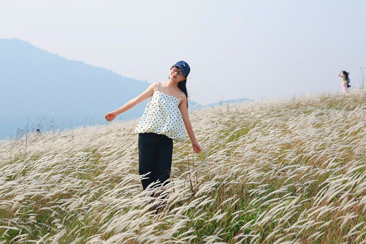 Tourists check-in at Tia Lo B grass hill, Pu Nhi commune, Dien Bien province. Photo: Dinh Nguyen