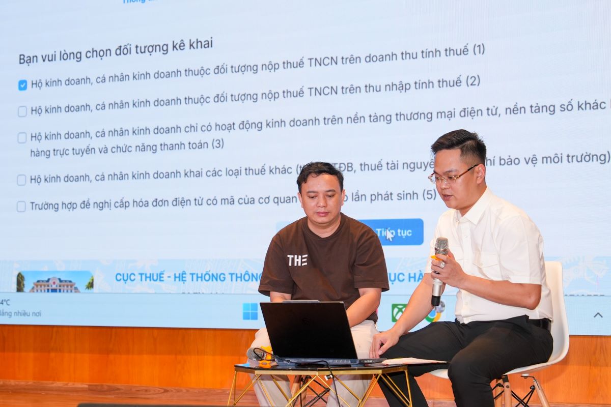 Hộ kinh doanh thực hiện thủ tục đăng ký thuế theo hướng dẫn của các cán bộ ngành thuế - Ảnh: Hữu Hạnh