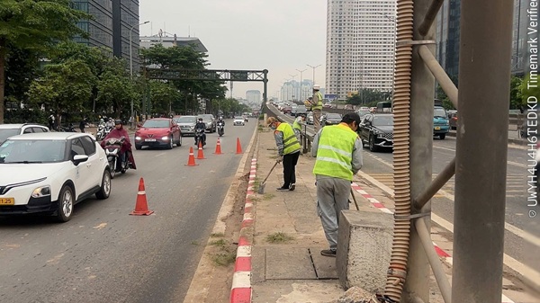 Công nhân Công ty CP Công trình giao thông 2 dọn dẹp vệ sinh tại nút giao Trung Hoà và các vị trí lên xuống vành đai 3. Ảnh: Quang Bảo 