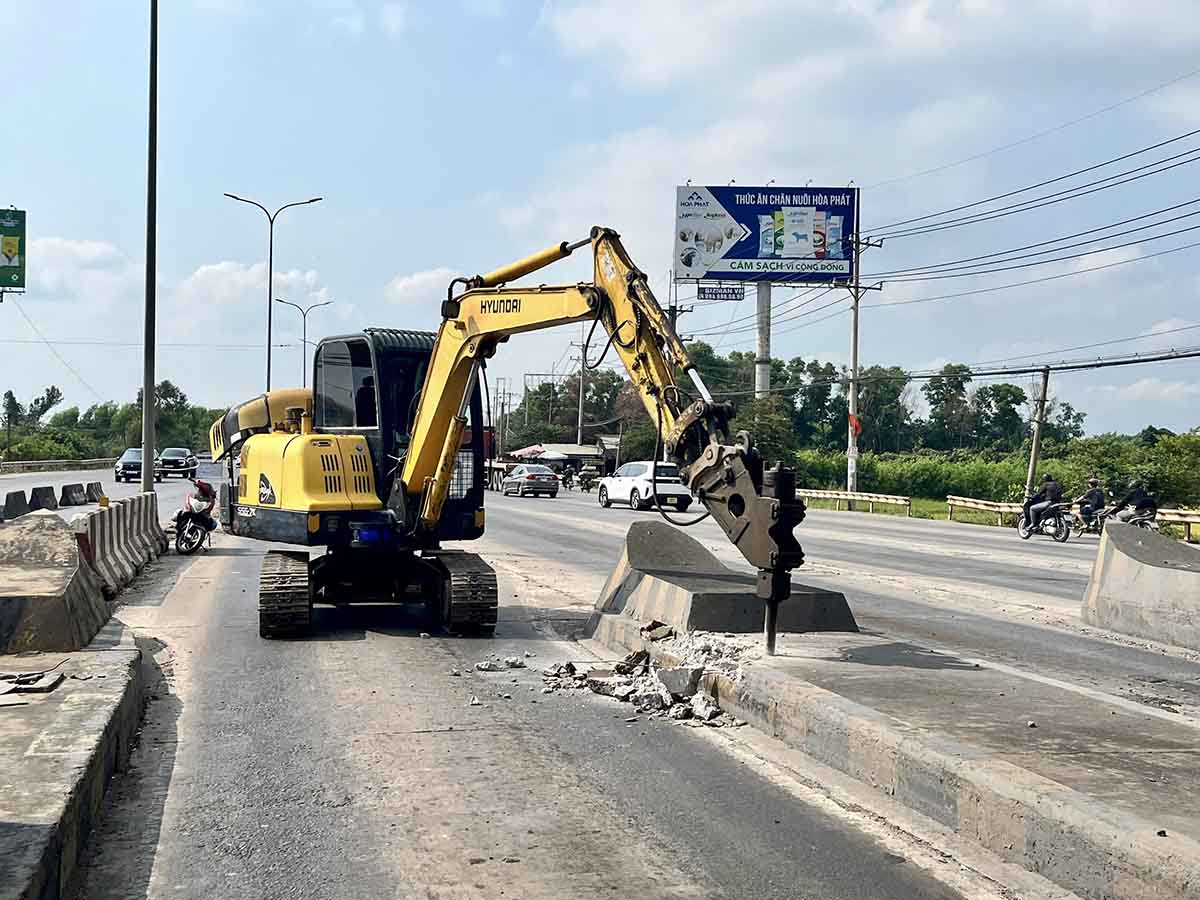 Công nhân xử lý các trụ bê tông còn lại của trạm thu phí. 