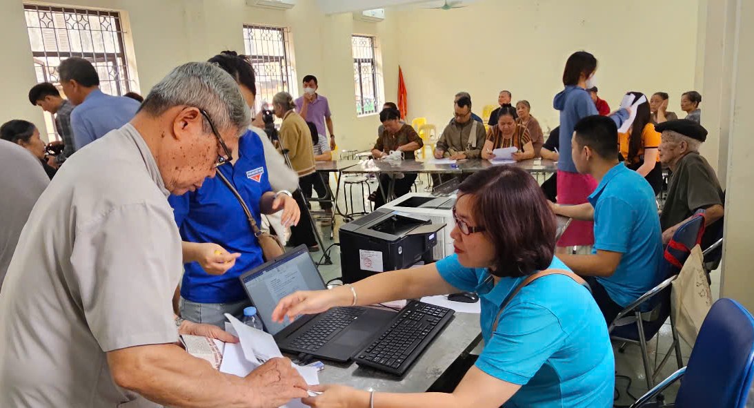 BHXH thành phố Hà Nội phối hợp với Trung tâm Phục vụ Hành chính công số 7 hỗ trợ, hướng dẫn người dân thực hiện ủy quyền nhận lương hưu, trợ cấp BHXH tại phường Hà Đông. Ảnh: BHXH Hà Nội