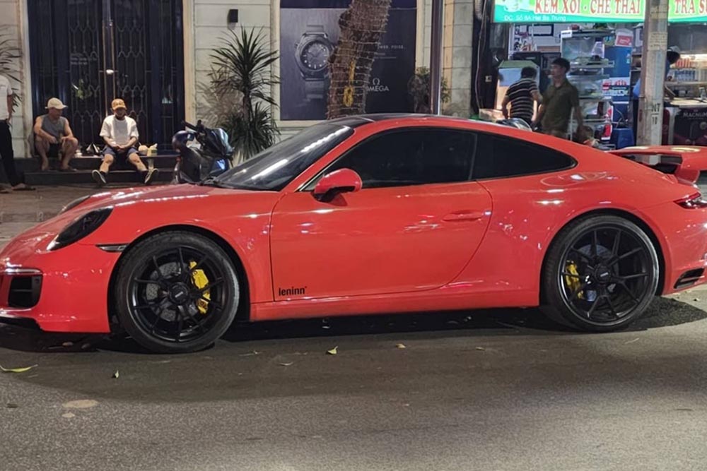 The Porsche 911 upgraded in a racing car style with a striking orange exterior appears on the streets of Hanoi. Photo: Minh Long