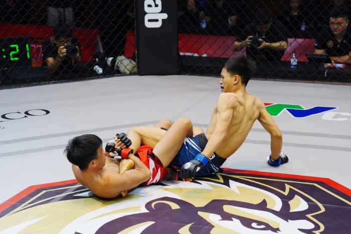 Hoàng Đức (đỏ) có cú bẻ chân chớp nhoáng trước võ sĩ trẻ Thành Công. Ảnh: MMA