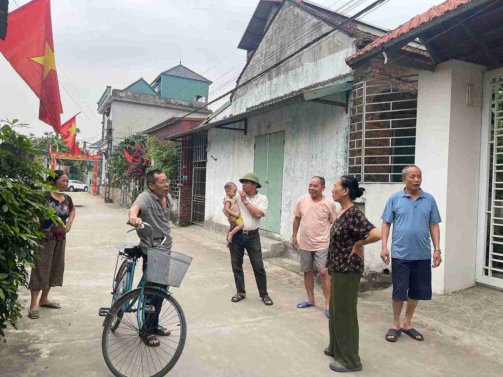 Người dân thôn Thuần Mỹ tập trung ngoài ngõ, bày tỏ bức xúc vì tình trạng mất nước sinh hoạt kéo dài. Ảnh: Mai Hương