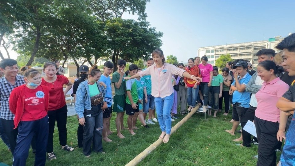 Công nhân khéo léo vượt qua cầu treo trong tiếng cổ vũ. Ảnh: Hoàng Lộc