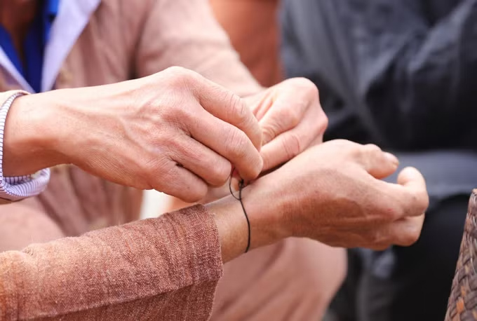 The person who is tied the thread to their wrist will always wear it on their body, and in any circumstances, it will not be removed until the ceremony to welcome the first thunder of the year next year. Photo: Xuan Tien/VNA