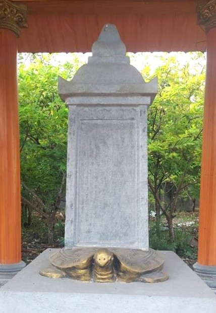 Tấm bia cổ được lưu giữ trong khuôn viên đền Quảng Cư. Ảnh: Thanh Tâm