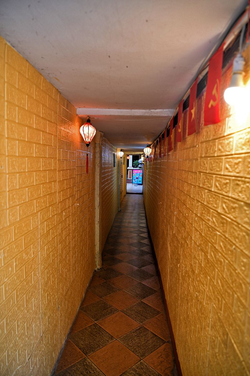 Bức tường màu vàng rực rỡ kết hợp với hàng cờ tạo nên một diện mạo hoàn toàn mới, sạch sẽ và tràn đầy sức sống. Ảnh: Việt Văn