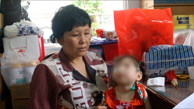 A mother with cancer hugs her brain-damaged child for treatment. Photo: Nguyen Ly