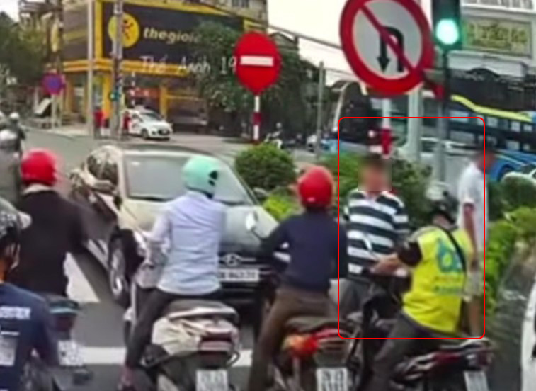 Tài xế xe máy bị hành hung trên đường (2 người trong khoanh tròn đỏ). Ảnh chụp màn hình