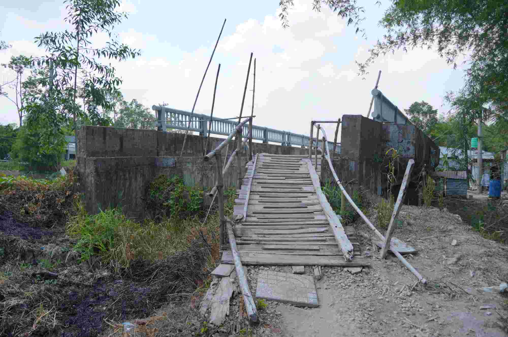 Without access roads to the bridge, local people are forced to make their own bamboo and wooden access roads to connect. Photo: Ta Quang