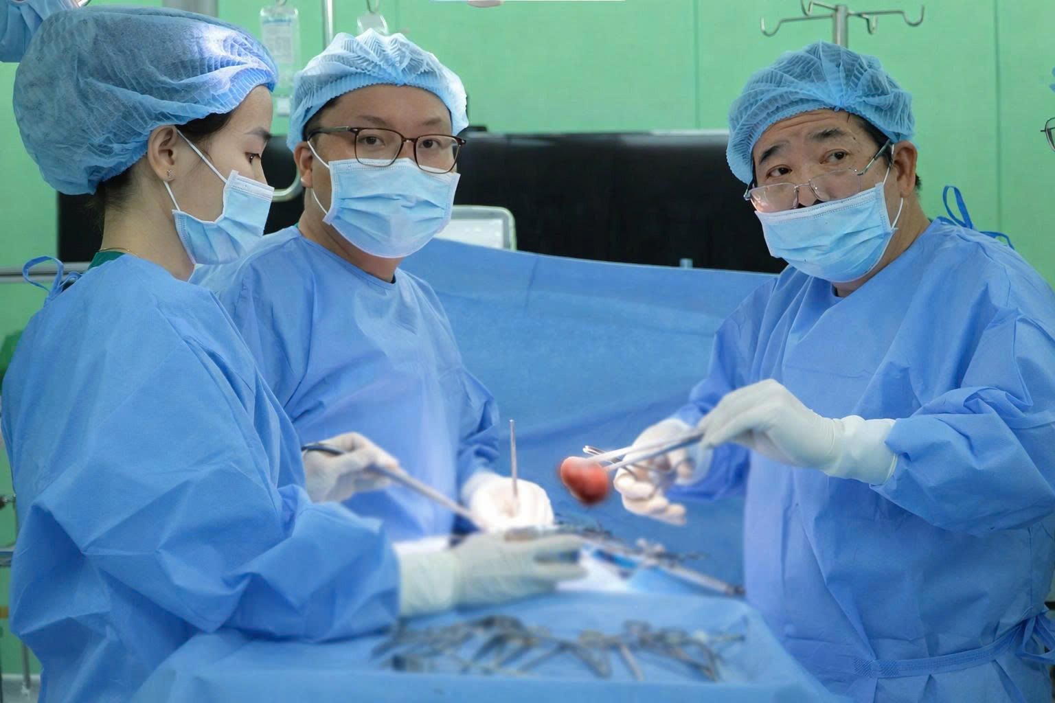 PGS. TS. BS Đàm Văn Cương cùng Ê-kíp phẫu thuật thực hiện lấy sỏi. Ảnh: Bệnh viện cung cấp