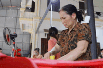 Ambiance animée à l'atelier de production de drapeaux nationaux à l'approche de la grande fête du 30 avril