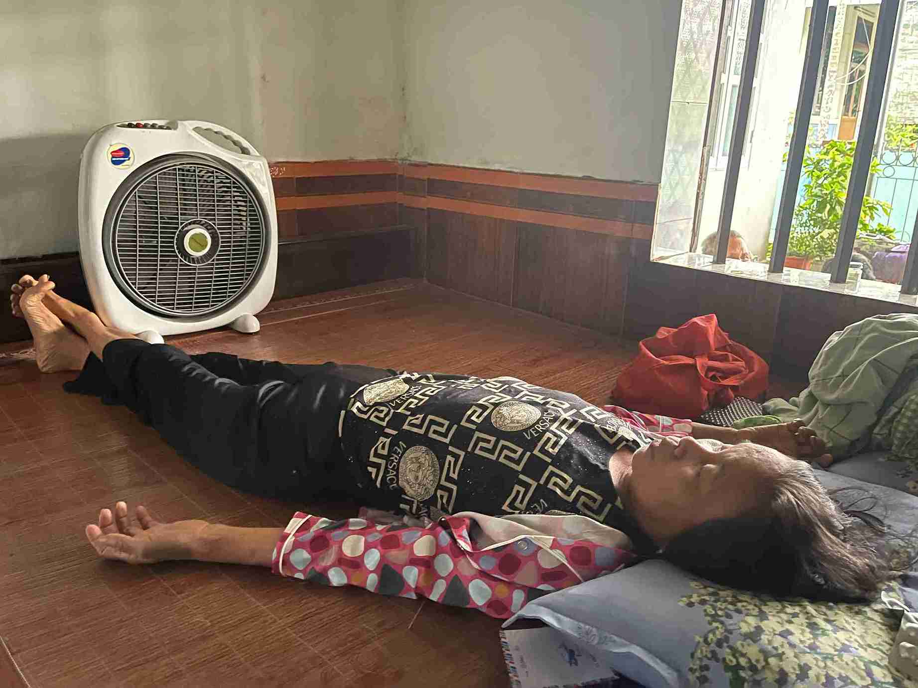Bà Nết nằm trên giường bệnh, sức khỏe suy kiệt, gần như không thể tự đi lại. Ảnh: Mai Hương