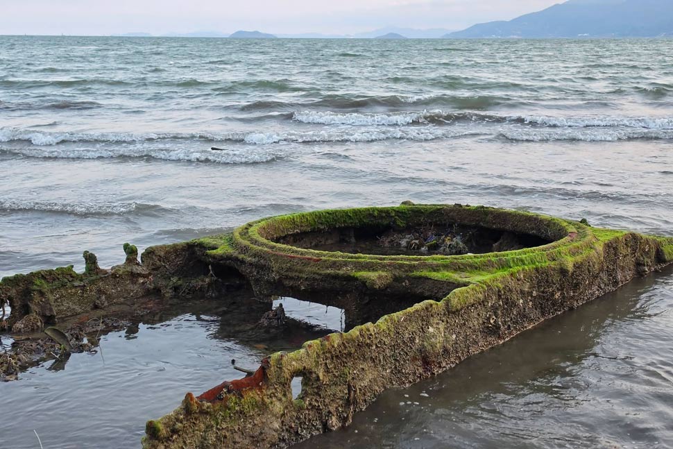 Vật thể kim loại lộ tại bãi biển Quy Nhơn nghi là bộ phận xe tăng thời chiến. Ảnh: Quốc Cường