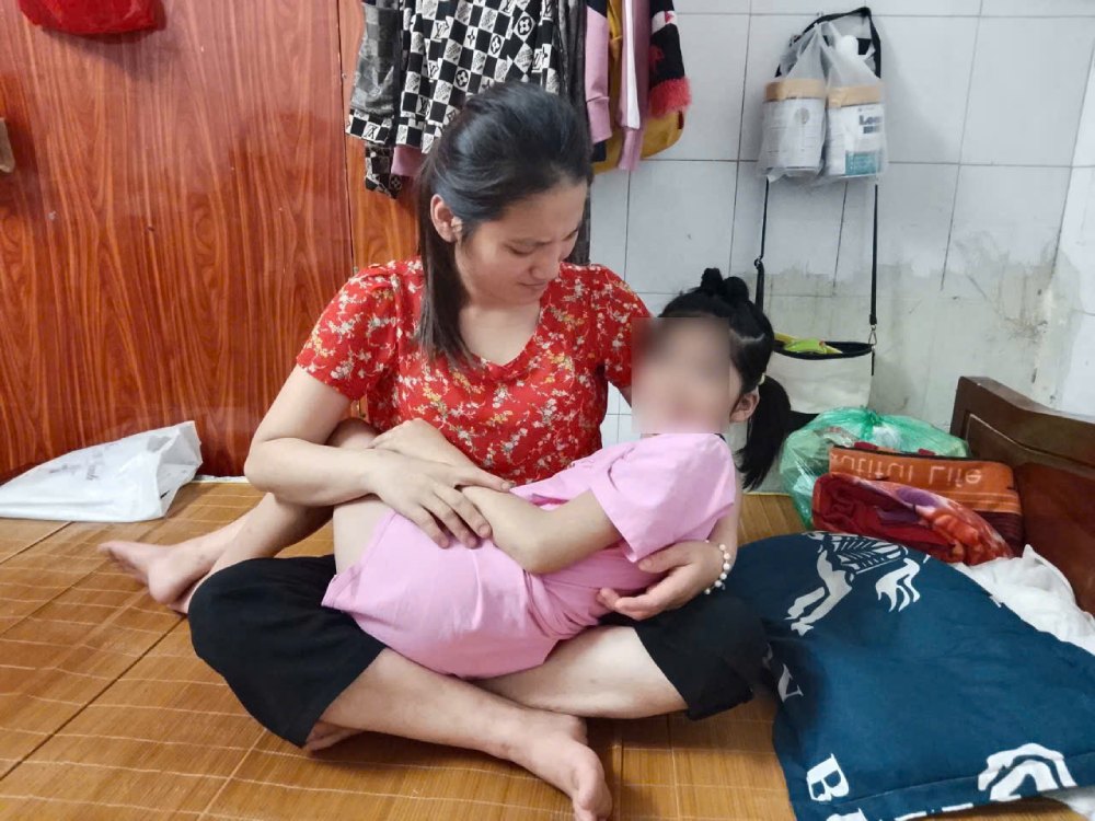 Mme Bui Thi Quynh - une mère pauvre - tient bébé Dang Dieu Linh dans ses bras pour réconforter son enfant. Photo : Fourni par la famille