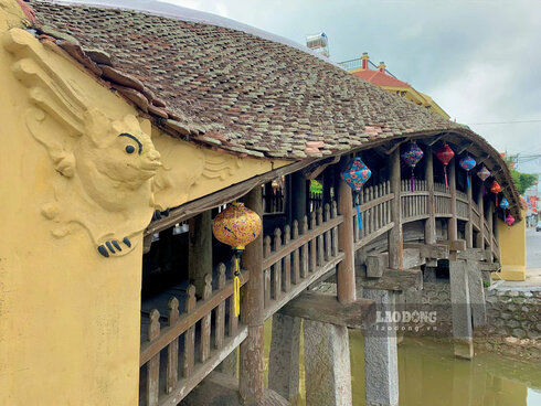 Hai bên lòng cầu là hai dãy hành lang và cũng được uốn cong theo thành cầu. Phía ngoài hành lang là lan can với các đố thượng, đố hạ và 162 con song dáng lá đề. Ảnh: Lương Hà