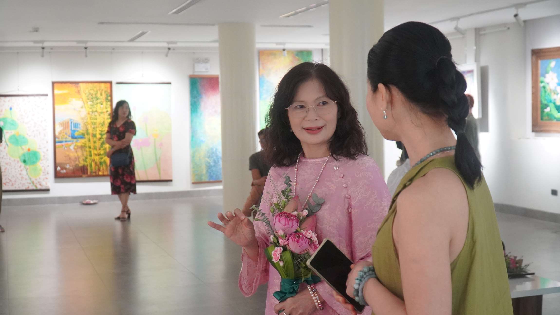 Giảng viên Nguyễn Thị Thu (Trung cấp nghề Thủ công Hà Nội) đã chia sẻ với du khách về ý tưởng và quá trình sáng tác bức tranh sen của mình. Ảnh: Minh Vũ