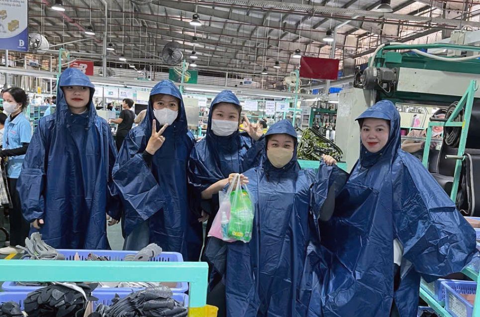 Đoàn viên mặc thử áo mưa cánh dơi do Công đoàn cơ sở tặng. Ảnh: CĐCS Công ty TNHH Freeview Industrial Việt Nam 