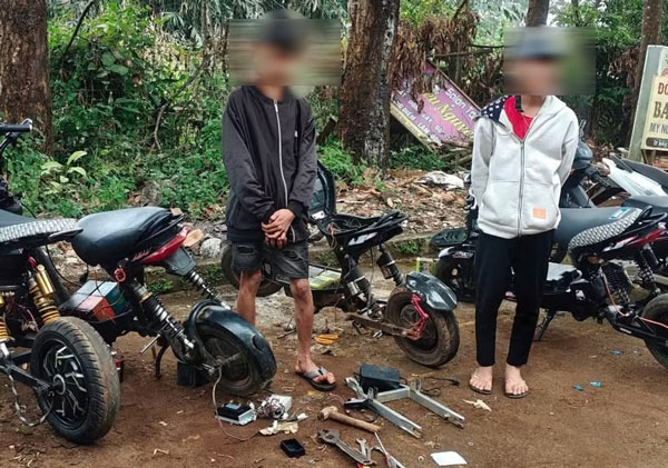 Các em học sinh mày mò, tìm cách độ chế thêm pin, nâng công suất xe máy điện. Ảnh: Công an 