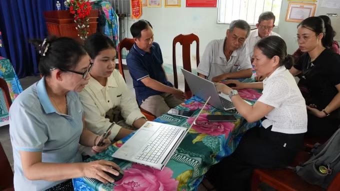 꽝응아이성 응옥바이사 프엉뀌 2 마을 지역 사회 디지털 기술 그룹 회원들이 온라인으로 행정 절차 서류를 제출하는 주민들을 안내하고 있습니다. 사진: 즈또안/TTXVN