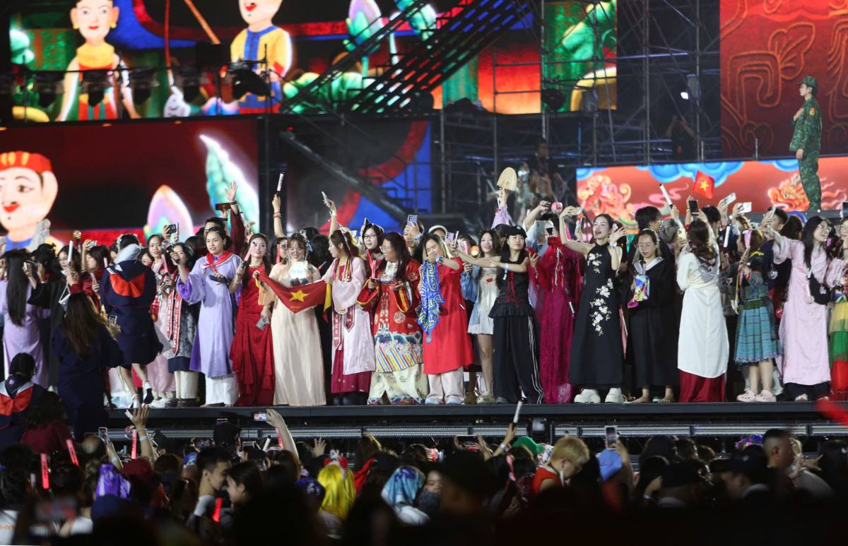Hàng trăm khán giả mặc trang phục truyền thống được mời lên trong tiết mục “Một vòng Việt Nam“. Ảnh: Hoàng Huê